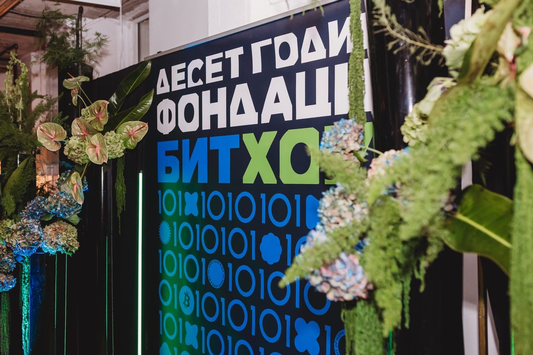 Decor detail from the Bithope Foundation 10-year anniversary in Sofia, featuring the brand's binary-code visual identity and floral arrangements.