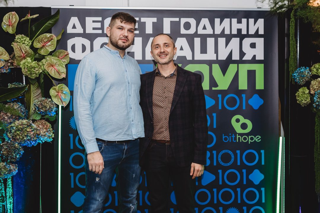 Founder Vladislav Dramaliev with a community attendee in front of the Bithope Foundation 10-year anniversary backdrop in Sofia.