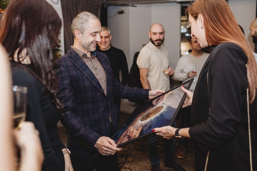 Founder Vladislav Dramaliev receives a framed commemorative bitcoin artwork during the Bithope Foundation 10-year anniversary.